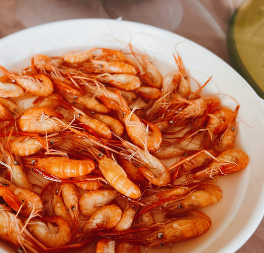 a white bowl filled with shrimp on top of a table