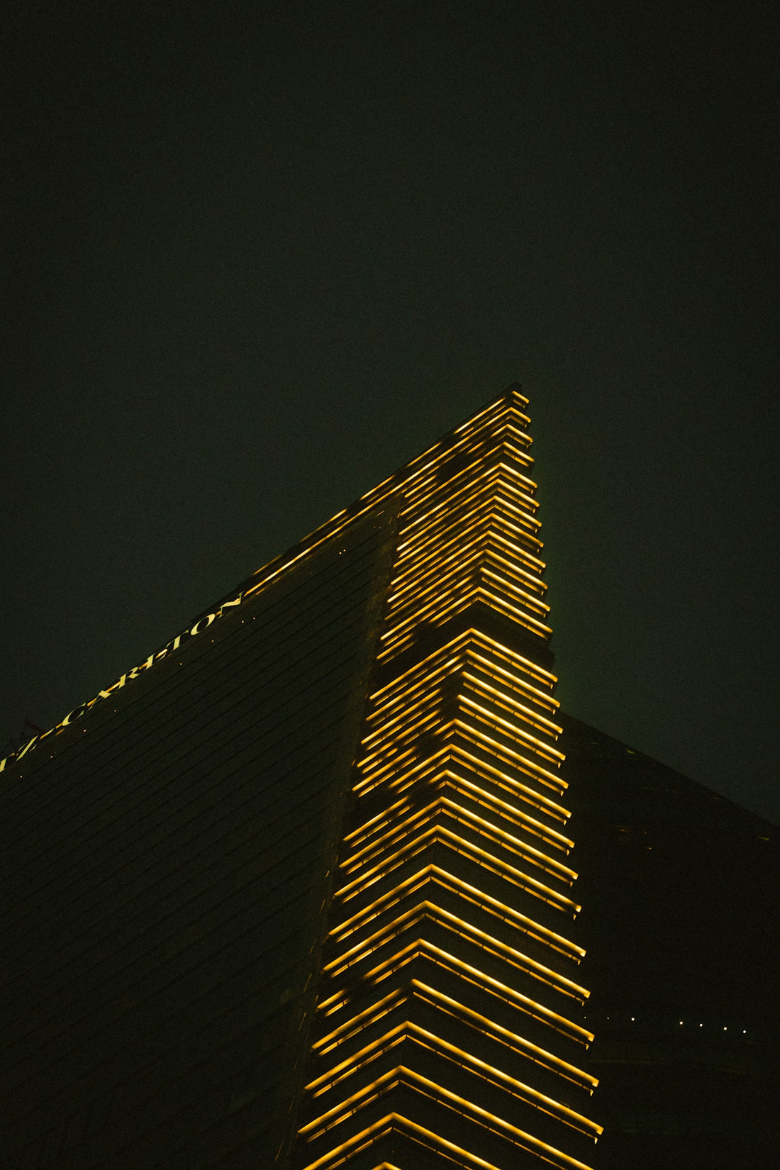 Building illuminated by golden lights at night.