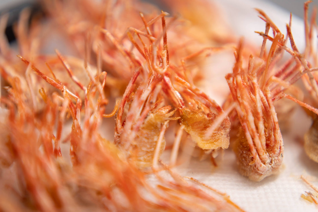 Close-up of fried shrimp with detailed legs and antennae.